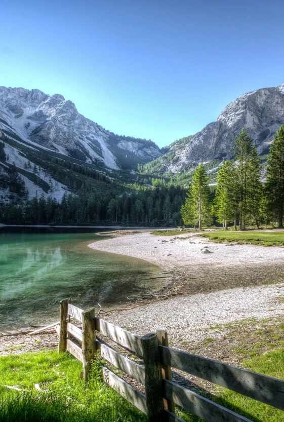 A lake with mountains in the background and trees.