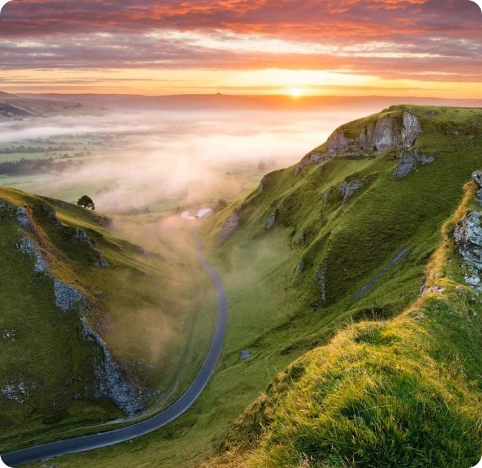 A view of the sun setting over a valley.